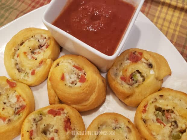 The baked pinwheels are served with warm marinara or pizza sauce on the side.