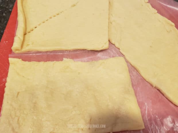 Crescent roll dough is separated into 4 rectangles, and perforations sealed.