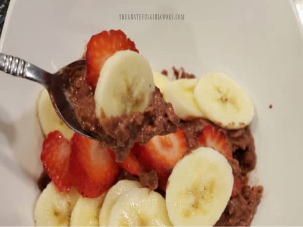 A spoonful of chocolate banana berry oatmeal, ready to be eaten.