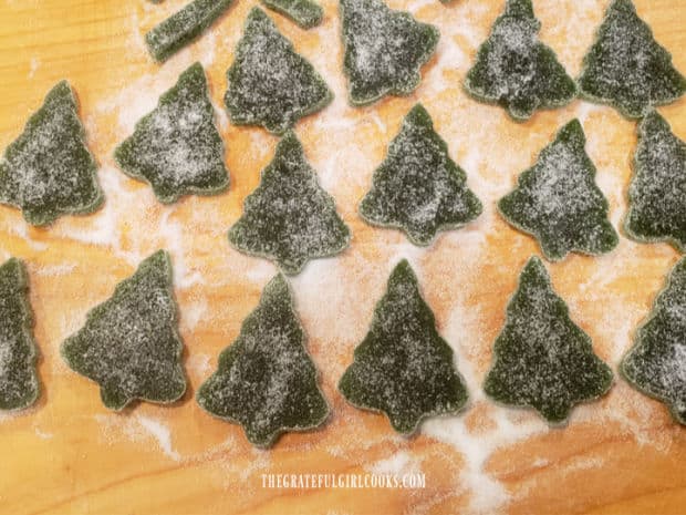 A lot of Christmas tree gumdrops on a cutting board, ready to be enjoyed.