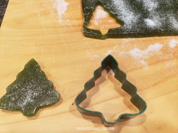 A small Christmas tree-shaped cookie cutter is used to cut out design from the gelatin.