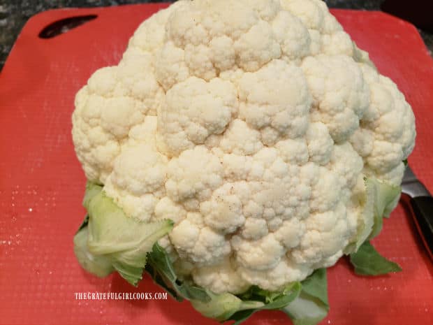 The outer leaves of a head of cauliflower are removed first.