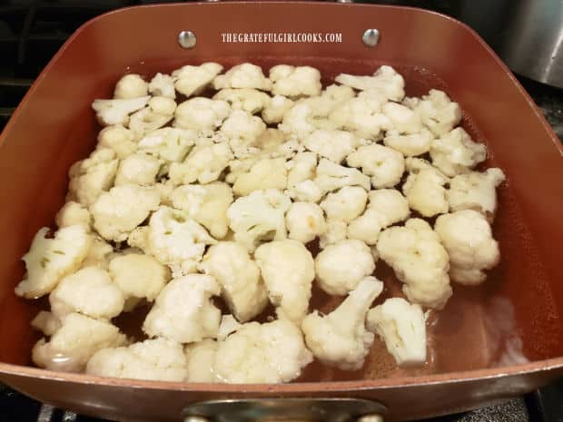 Boiling the cauliflower florets until tender.