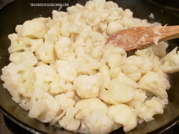 Onions and cauliflower are cooked together in skillet for about 7-8 minutes.