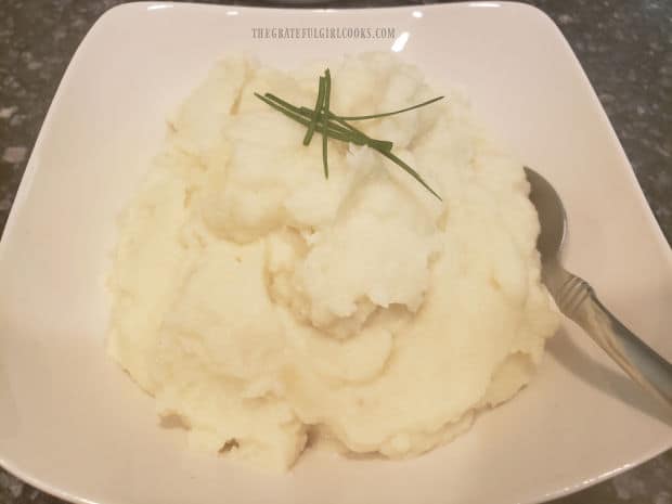 A serving bowl filled with creamy garlic mashed cauliflower, ready to eat.