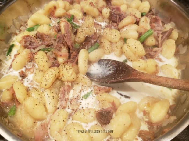 Seasonings and half and half are added to the ingredients for ham and cheddar gnocchi.