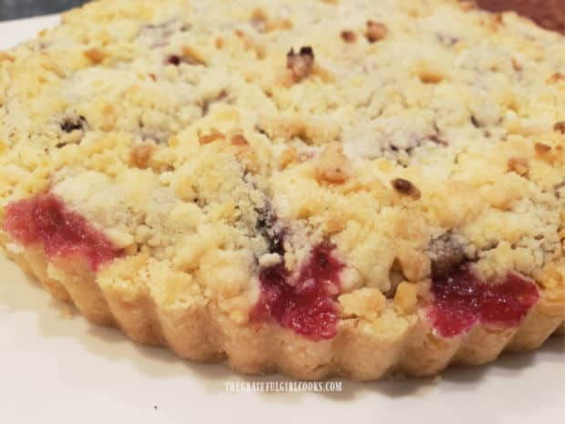 A side view of the crust edges of the plum-filled shortbread tart.