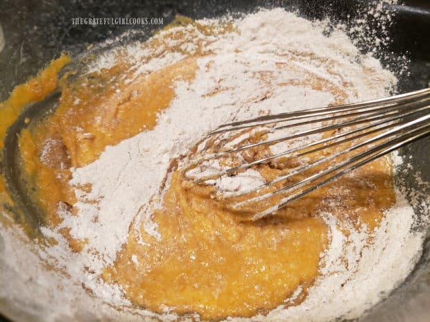 The dry ingredients are combined with the wet ingredients for the pumpkin pecan streusel muffins.