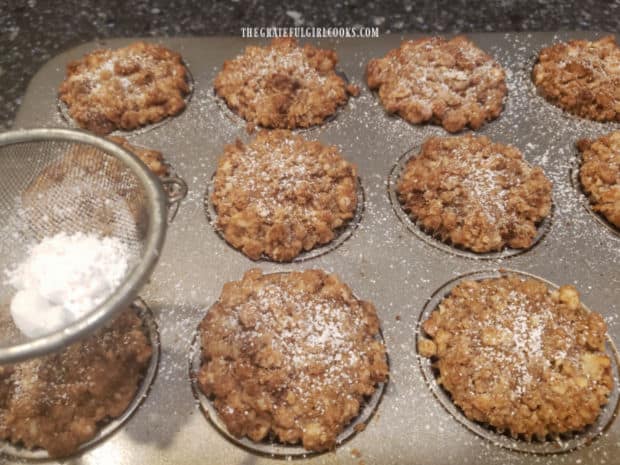 Powdered sugar is sifted onto the muffins after they finish baking.