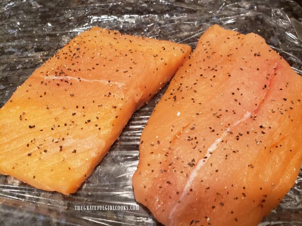 Salmon fillets are patted dry, then seasoned with salt and pepper before cooking.