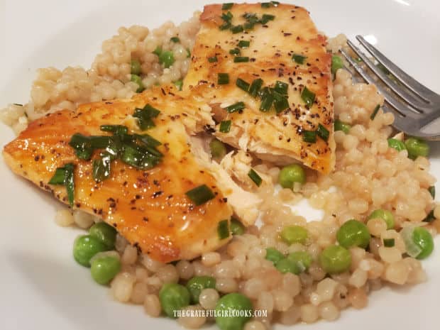 The salmon fillet in the Salmon and Pearl Couscous Bowl is fully cooked and flaky.