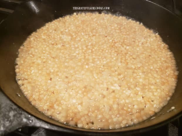 Water has been absorbed into the pearl couscous in the skillet.