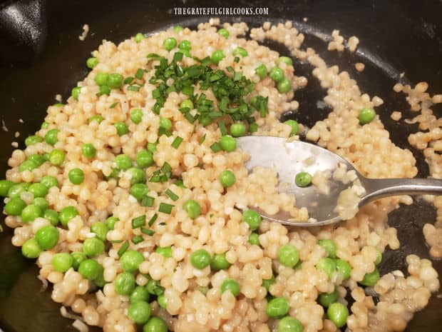 Chopped chives and lemon juice are added to the peas and pearl couscous for seasoning.