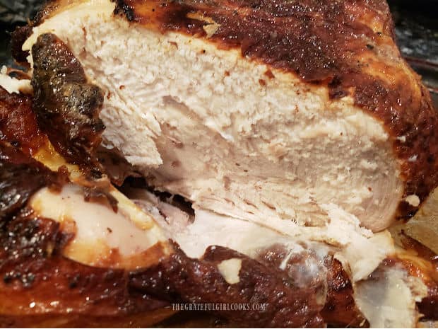 The inside of the air fryer whole chicken after cooking, now sliced and ready to serve.