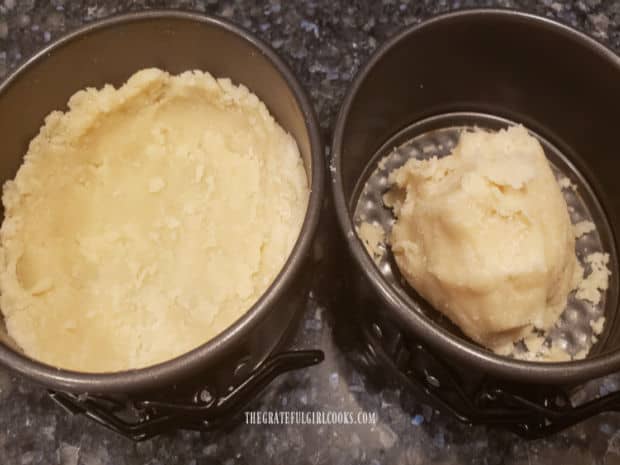 Dough is divided into two 4" tart pans and pressed to make crust on bottom and sides.