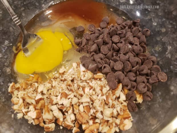 Ingredients for the chocolate pecan tart filling are combined in a large mixing bowl.