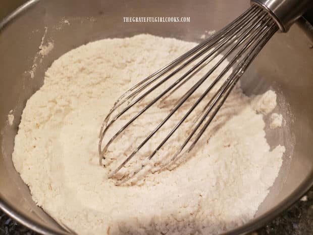 All purpose flour and baking powder are whisked together in bowl.