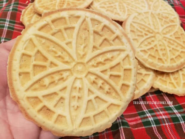 Holding up one of the crisp, classic pizzelle cookies, which is ready to be enjoyed!