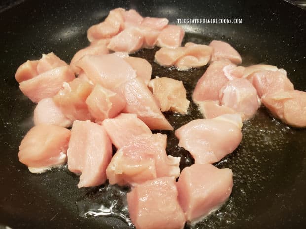 Cubes of chicken breast are cooked in hot vegetable oil until lightly browned.