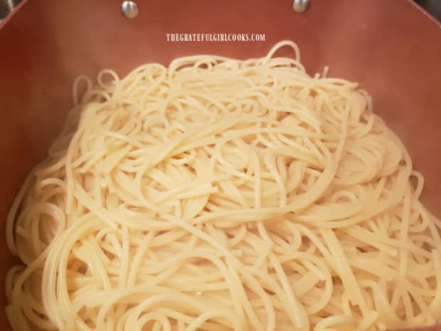 Spaghetti noodles are cooked, drained and then placed back into large saucepan.