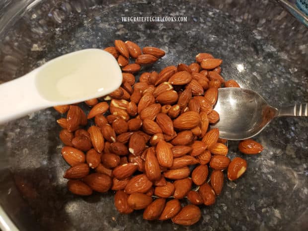 A teaspoon of vegetable oil is added to the smoky flavored almonds.