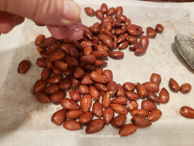 Roasted almonds are sprinkled with salt before serving.