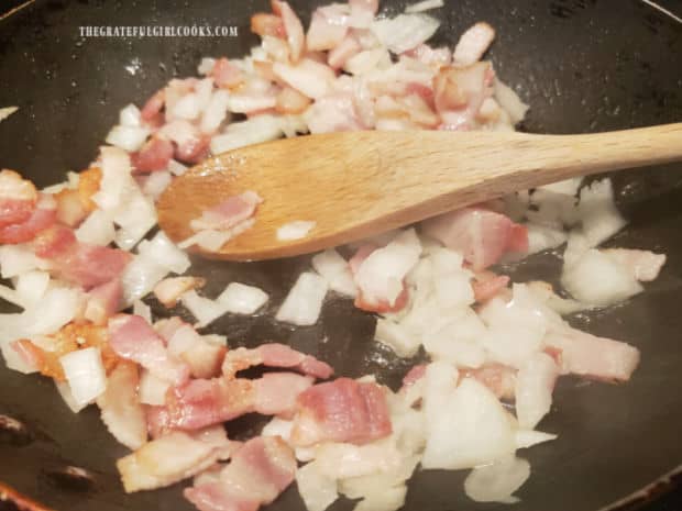 Bacon pieces are cooked in skillet along with chopped onion.