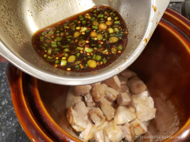 A seasoning sauce is mixed together and poured over the chicken in the crock pot.