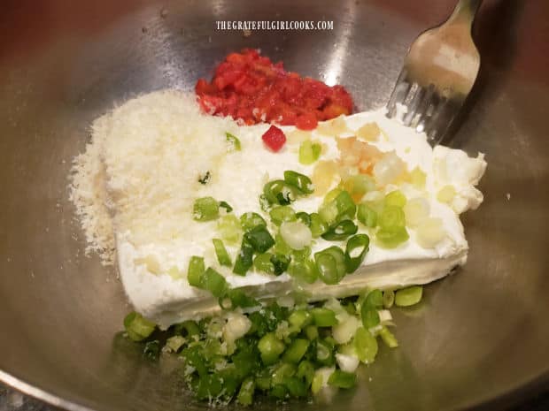 Cream cheese, pimientos, Parmesan, garlic and green onions are combined in bowl.