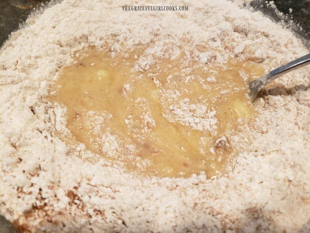 Dry ingredients are stirred into the pear pecan bread batter until combined.