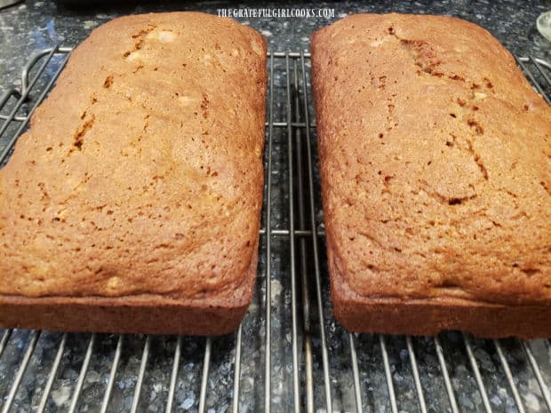 After baking, the loaves of pear pecan bread are browned and cool on a wire rack.