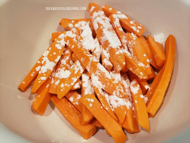 Cornstarch is tossed with the fries to coat them before baking (to help crisp them).