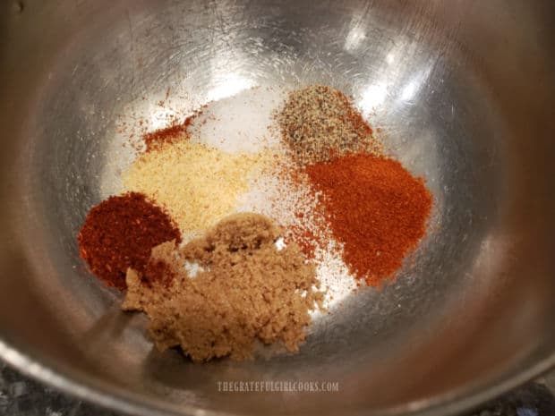 Spices are combined in bowl to season the roasted sweet potato fries before cooking.