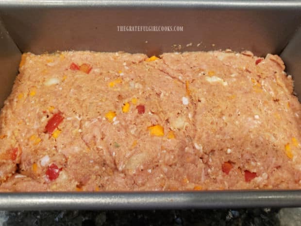 The meatloaf mixture is packed into a loaf pan for baking.