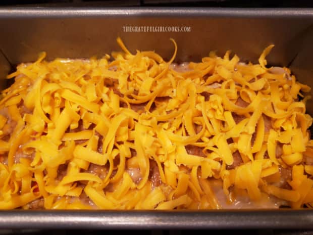 Grated cheddar cheese is added to the top of the meatloaf during baking time.