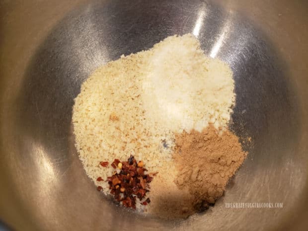 Panko crumbs, Parmesan cheese, garlic powder, ground ginger and red pepper flakes in bowl.