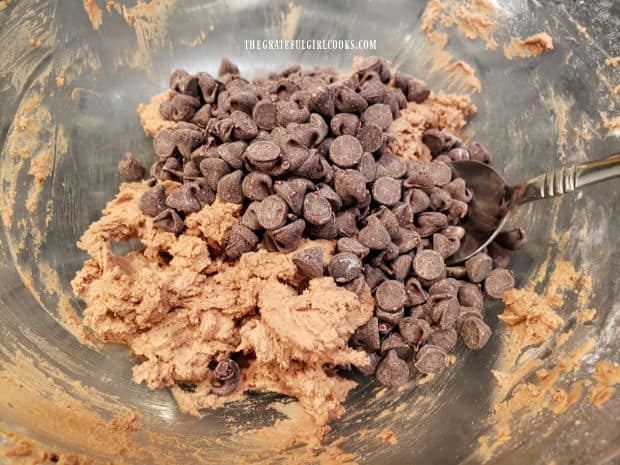 Semi-sweet chocolate chips are stirred into the cookie dough until combined.