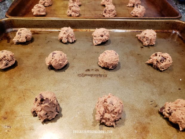 Tablespoons of dough for the chocolate mint cookie bites are placed on baking sheets to cook.