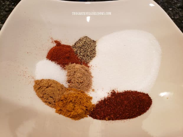 All of the spices to season the pecans are in a white bowl, ready to combine.