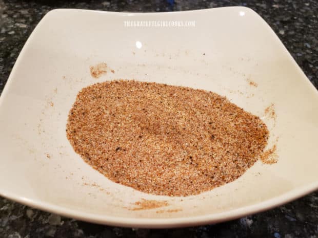 A white bowl, filled with the spice mixture that will be used to season the toasted pecans.