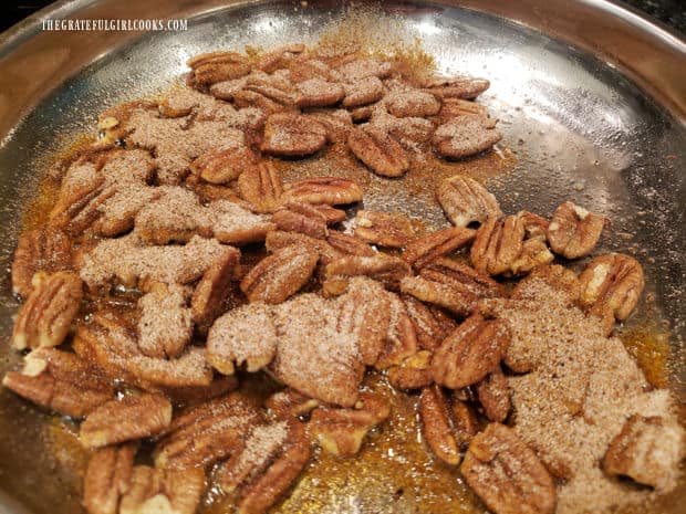 Pecans are covered with seasoning, then stirred to combine while heating.