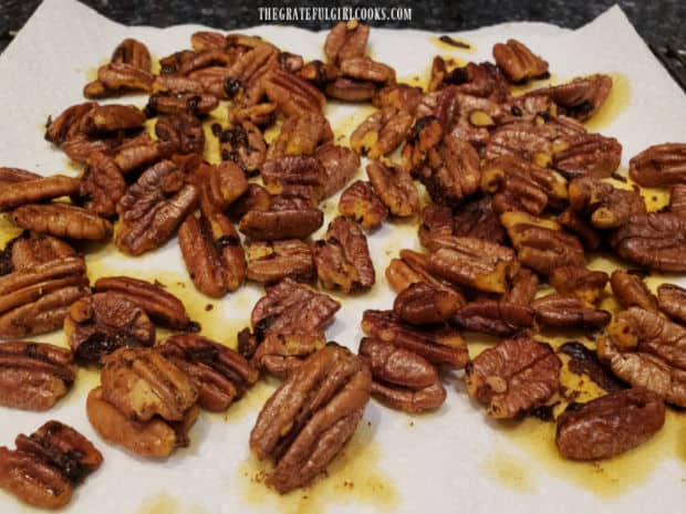 Draining the toasted sweet spiced pecans on paper towels to absorb oil.