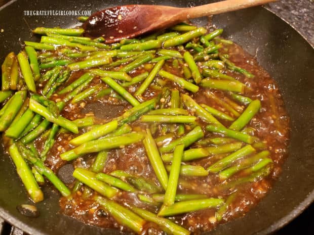 The stir fry sauce has thickened in the skillet with the asparagus.