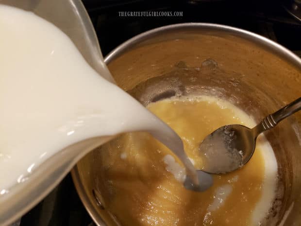 Milk is added to a butter and flour mixture in a saucepan.