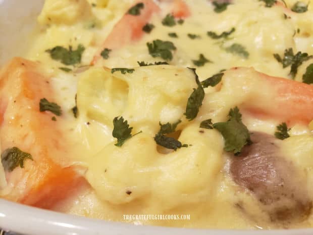 Cauliflower, potatoes and carrots are covered in a creamy cheese sauce.