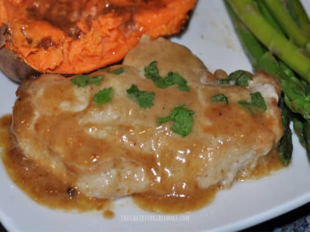 Creamy Honey Dijon Pork Chops are served, with asparagus and sweet potato on the side.