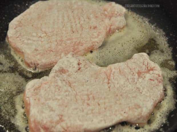 Seasoned/floured pork chops are pan-seared in a skillet with oil and butter.