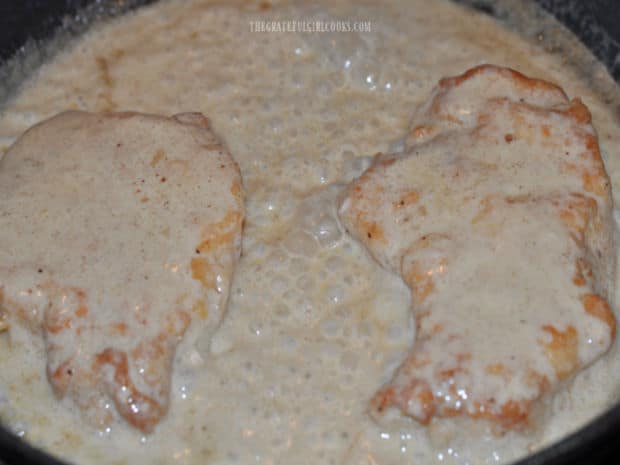 Creamy honey Dijon pork chops continue cooking in the sauce until done.