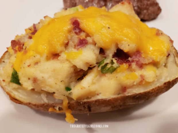 One of the double stuffed potatoes on a white plate, ready to eat and enjoy!