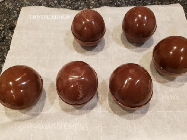 The tops of the chocolate spheres are added to the bottom half, and then cooled to set.